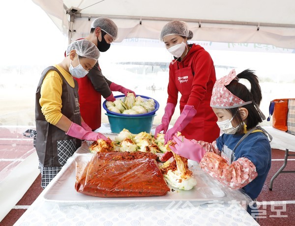 ▲ 2020 괴산김장축제 드라이브스루 김장체험에 참여한 한 가족이 김장김치를 담고 있다.