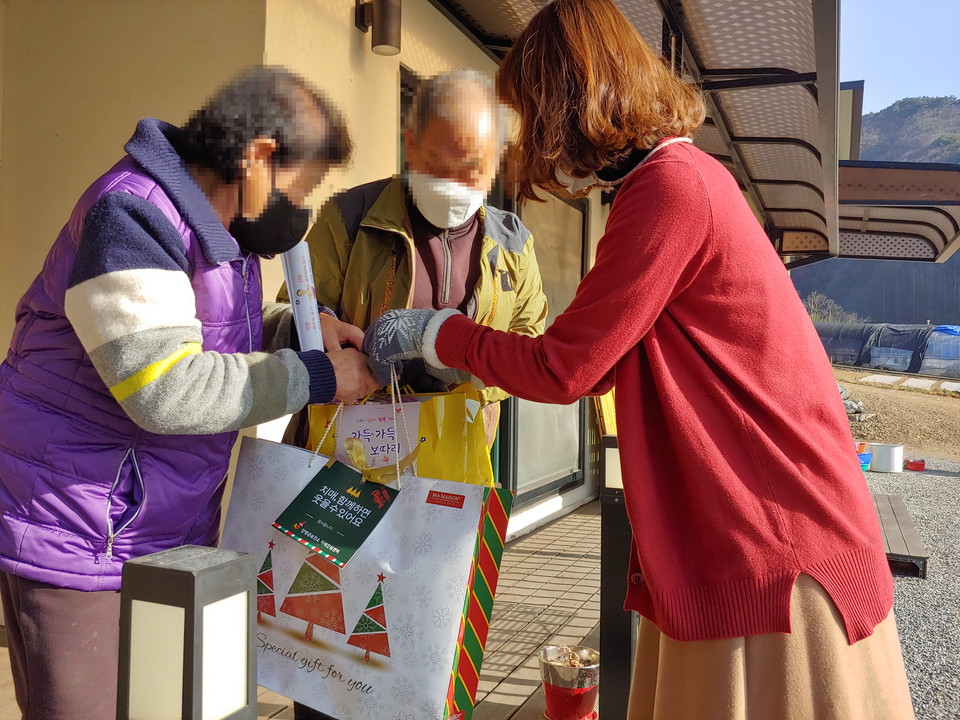 ▲ 단양군치매안심센터 직원(오른쪽)이 한 치매노인 가정을 방문해 '기억보따리'를 전달하고 있다. 사진=단양군제공