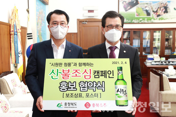 ▲ 정찬우 (주)충북소주 대표(왼쪽)와 이시종 충북지사가 산불예방 홍보 협약을 맺은 뒤 기념사진을 찍고 있다. 