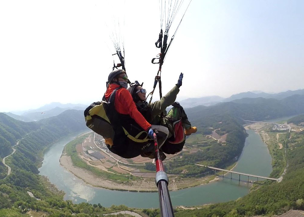▲ 단양 두산활공장을 출발한 패러가 하늘을 날고 있다. 아래는 단양강 상류인 가곡면 덕천마을. 사진=패러에반하다제공