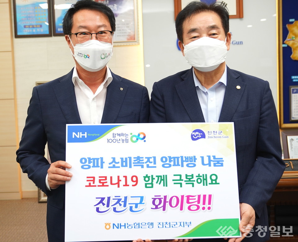 ▲ 농협진천군지부 정태흥 지부장이 9일 충북 진천군청에서 송기섭 군수에게 양파 빵을 기탁한 뒤 기념촬영하고 있다.