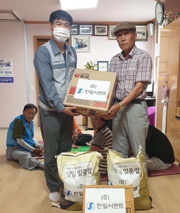 ▲ 한일시멘트 단양공장 장영진 관리과장(왼쪽)이 경로당에 쌀 등을 전달하고 있다. 사진=한일시멘트제공