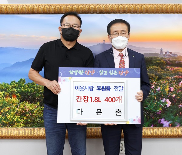 ▲ 단양 다믄촌 이창환 대표(왼쪽)가 김문근 단양군수에게 간장을 전달하고 있다. 사진=단양군제공