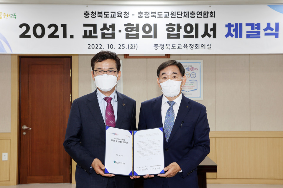 ▲ 윤건영 충북교육감(왼쪽)과 서강석 충북교총 회장이 2021 교섭 협의 합의서에 서명한 뒤 기념촬영을 하고 있다