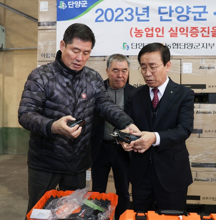 ▲ 김영기 단양농협 조합장(왼쪽)이 김문근 군수에게 전동가위 작동법을 설명하고 있다. 사진=단양군제공