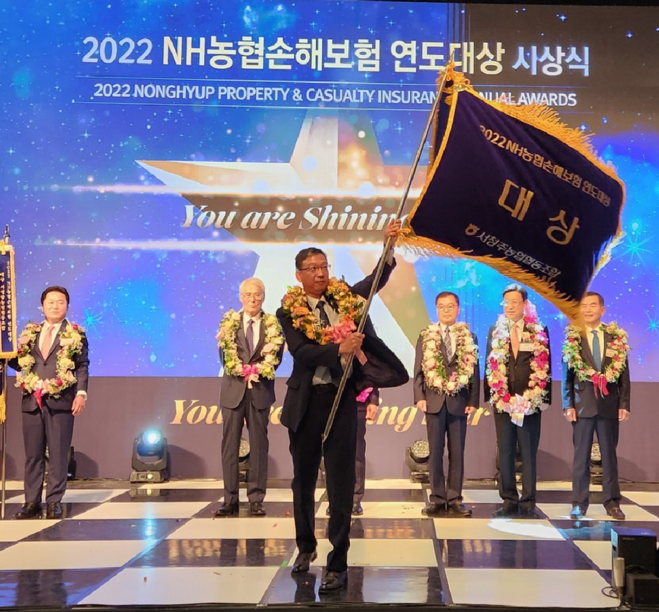 ▲ 유호광 서청주농협 조합장이 NH농협손해보험 연도대상 시상식에서 대상을 수상하고 대상 깃발을 흔들고 있다.