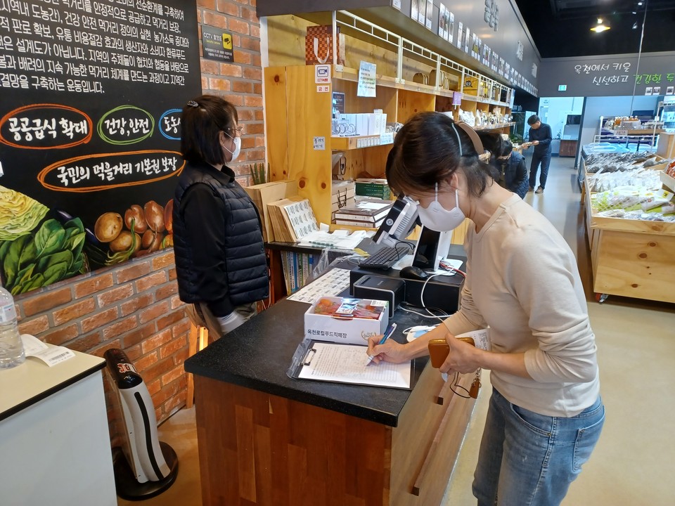 ▲ 지난달 충북 옥천로컬푸드직매장을 이용하는 한 주민이 정부의 지역사랑상품권 가맹점 제한 재검토를 촉구하는 서명운동에 동참하고 있다.