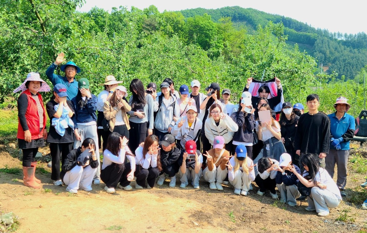 ▲ 세명대 뷰티케어학과 학생들이 일손이음 활동을 마치고 농가들과 사진촬영을 하고 있다. 사진=세명대제공