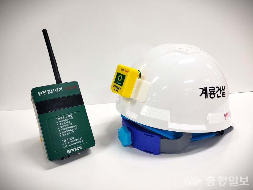 ▲ 안전경보장치 송신기(왼쪽 초록색 기기)와 수신기(오른쪽 안전모에 부착된 노란색 기기)