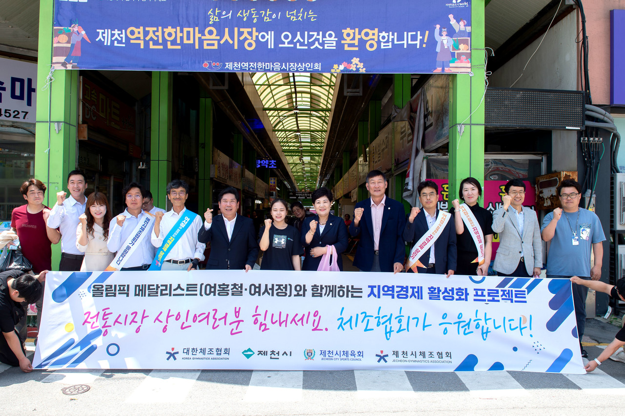 ▲ 여서정 제천시청 소속 체조선수가 제천역전한마음시장에서 장보기를 마친 후 관계자들과 기념촬영을 하고 있다. 사진=제천시제공