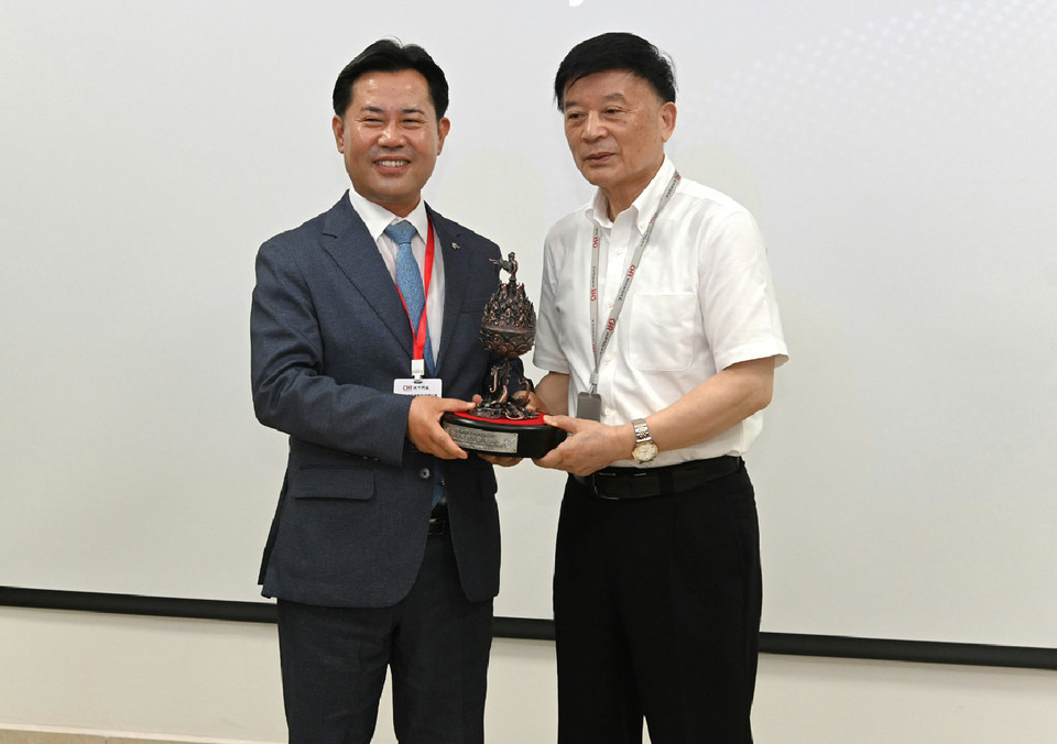 박정현 부여군수(왼쪽)가 중국 항커기업 차오 지 회장에게 투자 결정에 대한 답례로 기념품을 전하며 사진을 찍고 있다.