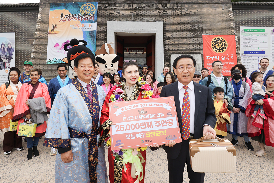 ▲ 김문근 군수(오른쪽)와 조성룡 군의장(왼쪽)이 온달관광지에서 2만5000번째 관광주민증 주인공 아제르바이젠에서 온 타흐미나 아슬라노바씨에게 선물을 전달하고 기념촬영을 하고 있다. 사진=단양군제공