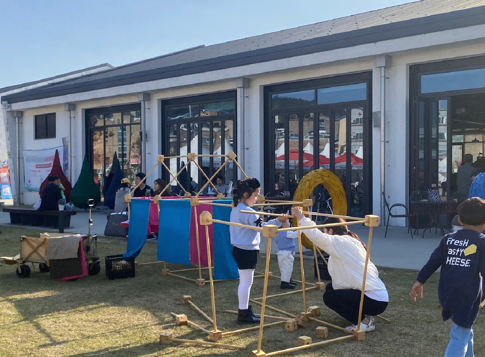 동부창고 카페C 야외광장을 찾은 가족이 목공으로 만든 '미니어처 놀이 도구'를 조립하고 있다.