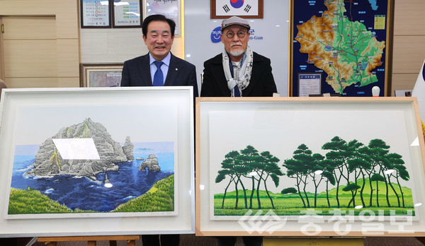 김준권 화백(오른쪽)이 6일 충북 진천군청에 송기섭 군수에게 자신의 작품 2점을 기증한 뒤 기념촬영하고 있다.
