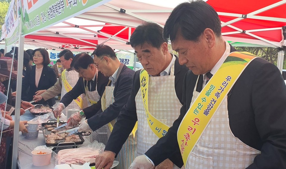 ▲ 황종연 충북농협 총괄본부장(오른쪽 첫번째)과 변익수 내수농협 조합장(두번째) 등 관계자들이 삼겹살을 구워 고객들에게 나눠주고 있다.