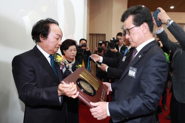 ▲ 오영식(왼쪽) 한국BBS 충북연맹 회장이 18회 충북도민대상 시상식에서 이시종 충북지사에게 선행봉사부문 대상 상패를 받고 있다.