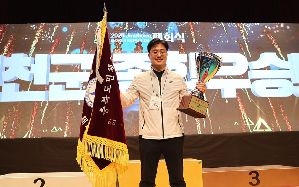 김명식 진천군 체육회장이 폐회식에서 종합우승트로피와 우승기를 들어올리고 있다.