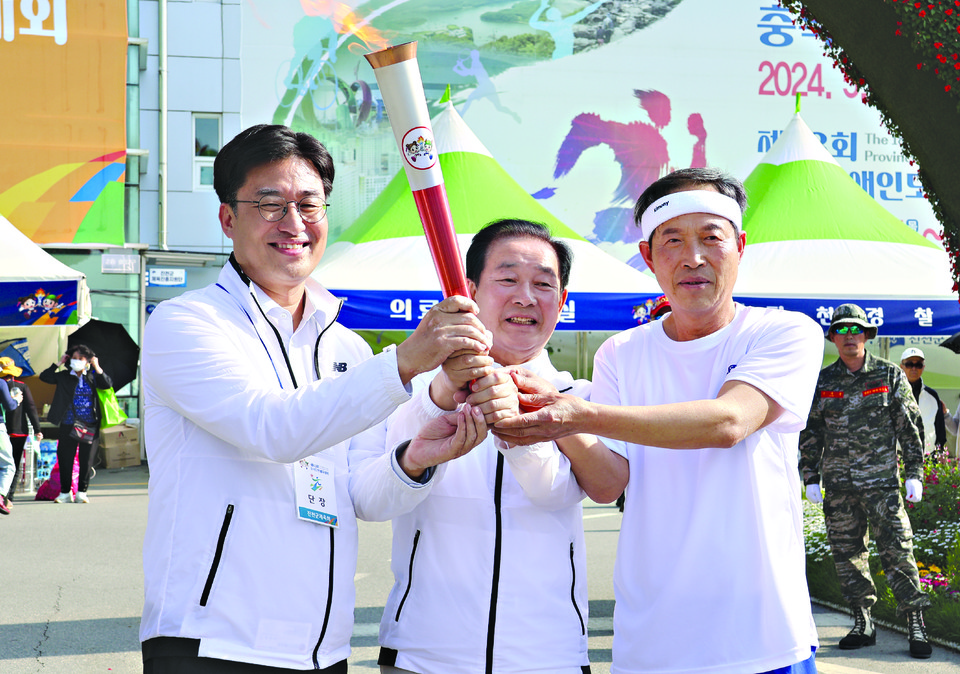 김명식 진천군 체육회장(왼쪽)이 송기섭 진천군수(가운데) 등과 개회식장에 도착한 성화를 받아들고 있다.