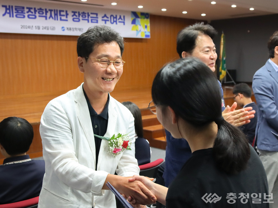 ▲ 사진 좌측 이승찬 이사장이 학업 우수자에게 장학증서와 장학금을 전달하고 있다