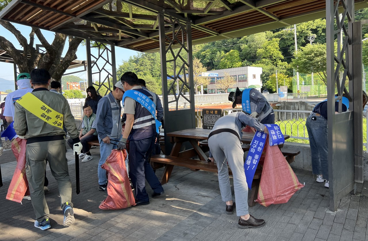 ▲ 지난 12일 한일시멘트 단양공장 직원들이 노조설립 기념행사로 매포읍 매포천 주민쉼터 일원에서 쓰레기를 줍고 있다. 사진=한일시멘트제공