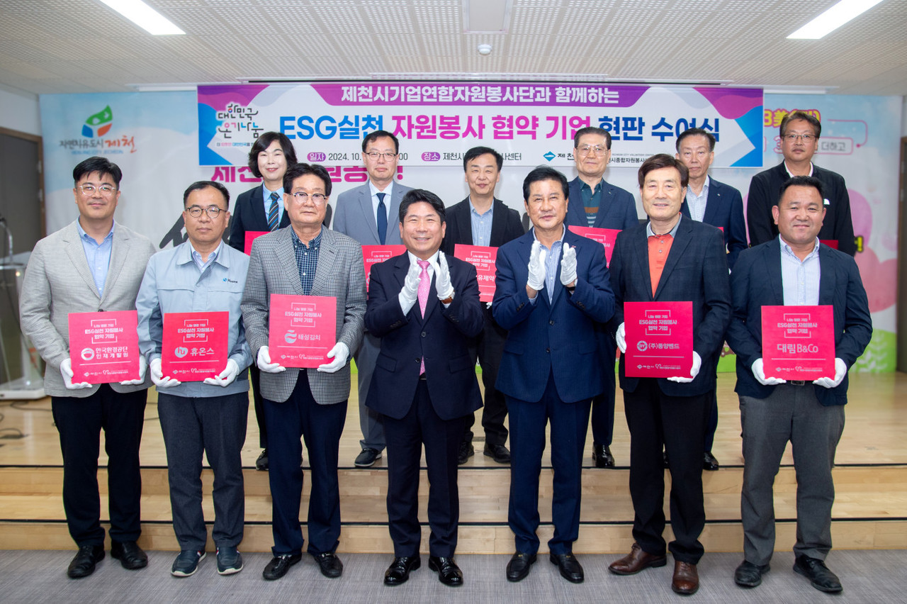 ▲ 제천시종합자원봉사센터와 지역 12개 기업연합자원봉사단이 ‘ESG실천 자원봉사 협약 현판 수여식’을 갖고 있다. 사진=제천시제공