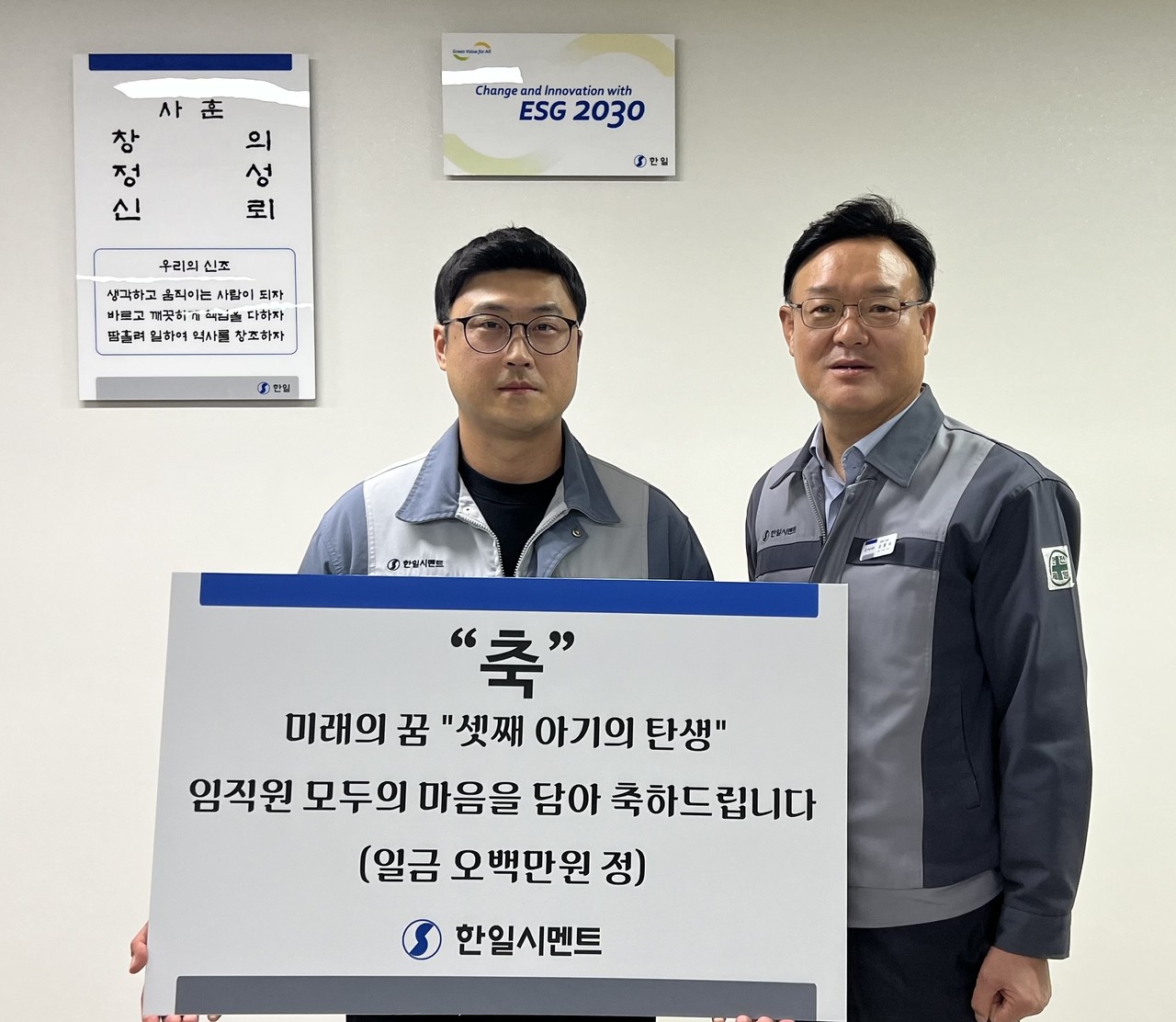 ▲ 심용석 한일시멘트 단양공장장(오른쪽)이 셋째 아이를 출산한 김동배 직원에게 출산축하금을 전달하고 있다. 사진=한일시멘트제공