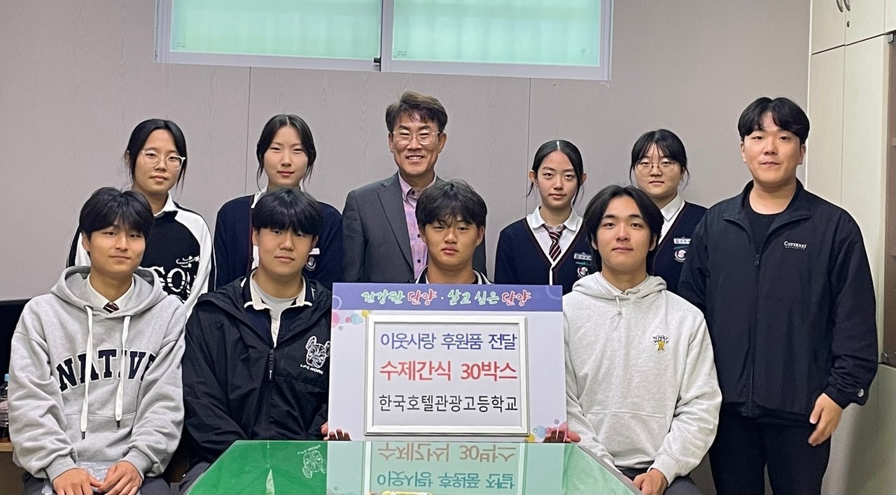 ▲ 한국호텔관광고 제빵 동아리 학생들이 손문영 군 사회복지과장(뒷줄 가운데)에게 간식을 전달하고 사진촬영을 하고 있다. 사진=단양군제공