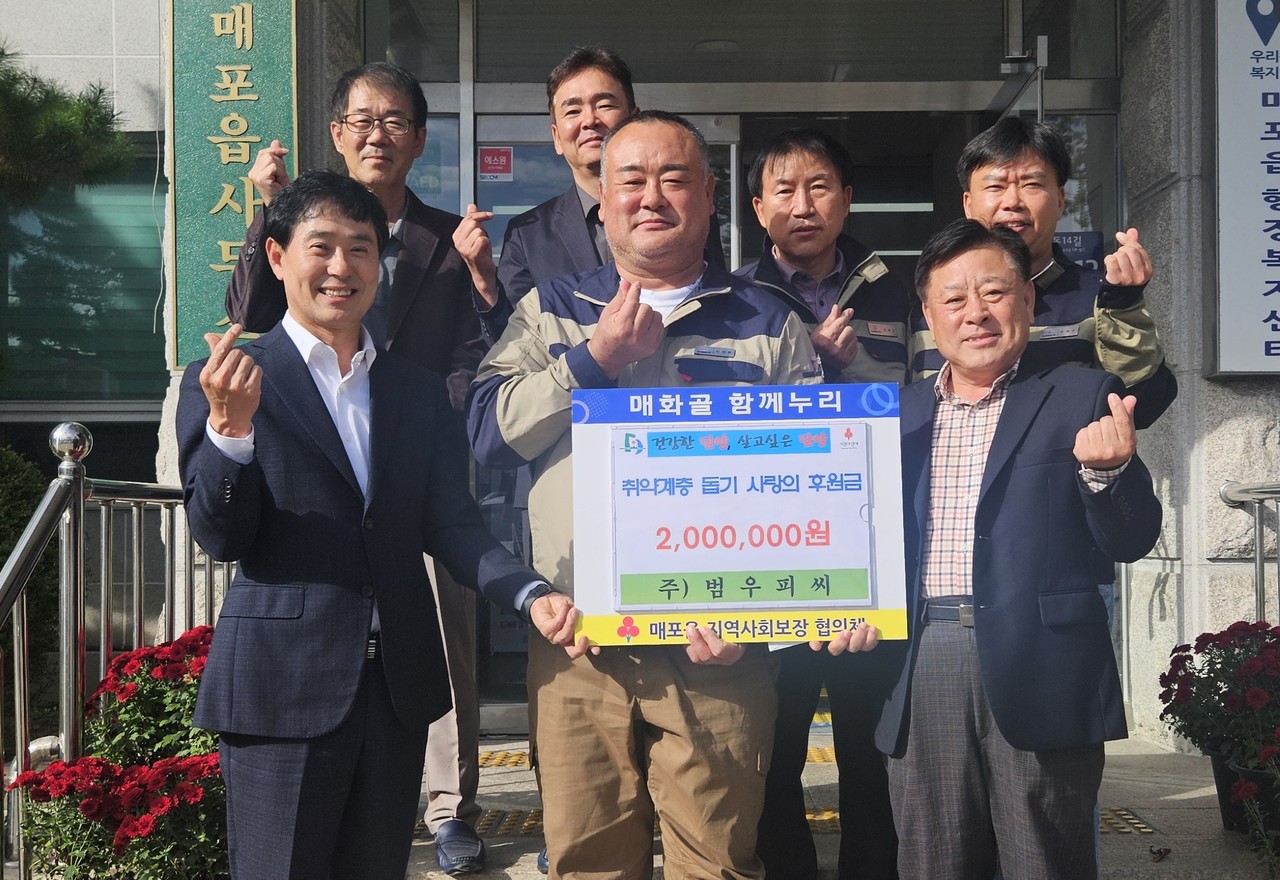 ▲ 김성환 대표(앞줄 가운데)가 매포읍지역사보협에 성금을 전달하고 있다. 사진=단양군제공