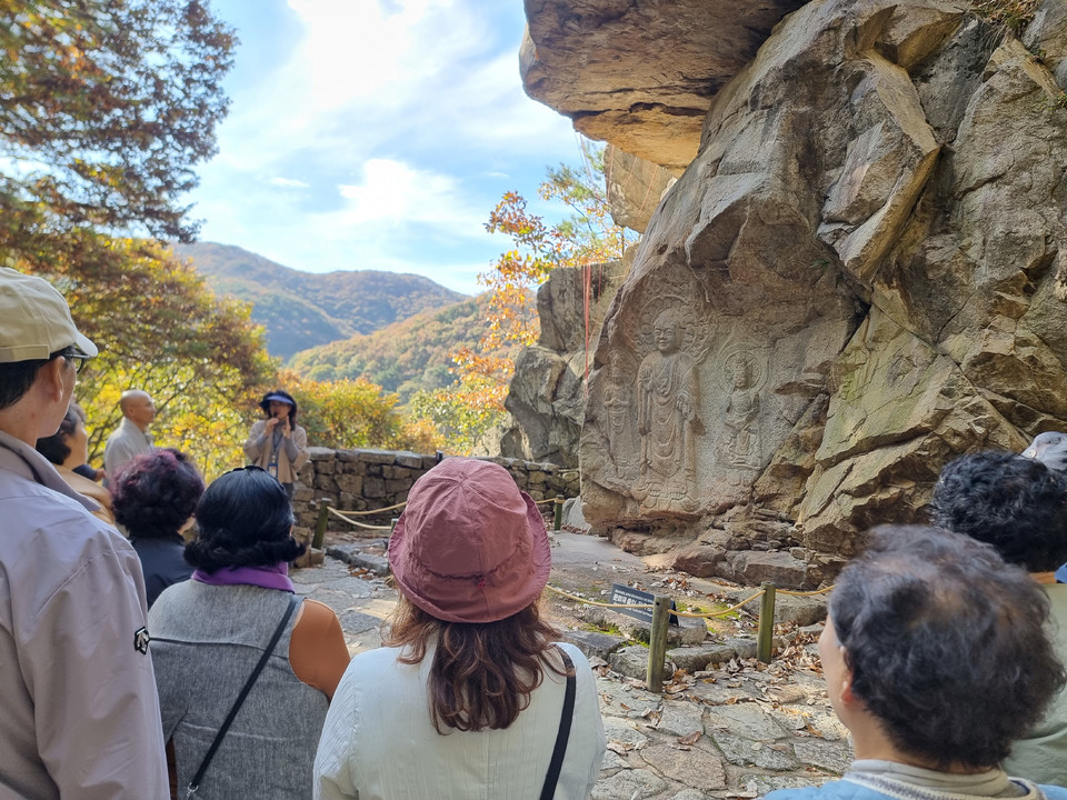 ▲ 단풍이 곱게 물든 가을산을 배경으로 관광객들이 관광해설을 듣고 있다.