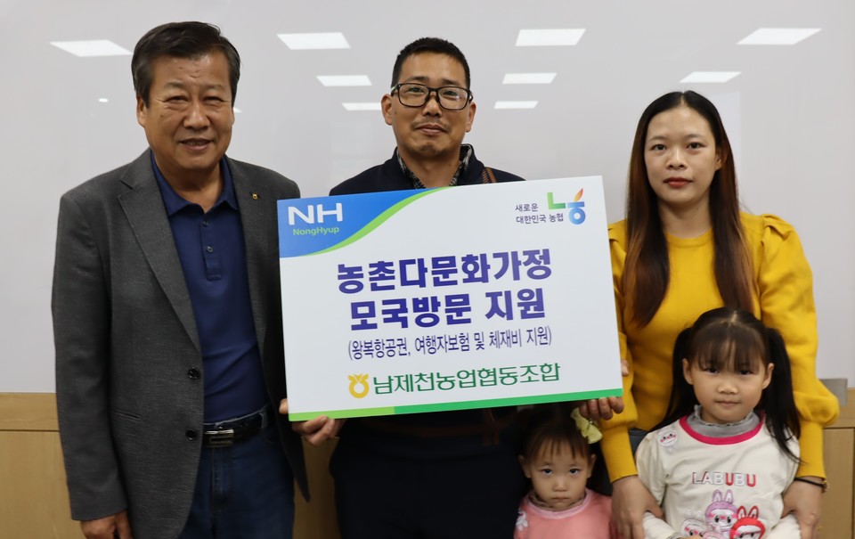 ▲ 류승인 남제천농협 조합장(왼쪽)이 김진영 조합원 가족에게 처갓집 방문 항공권 등을 전달하고 있다. 사진=농협제천시지부제공