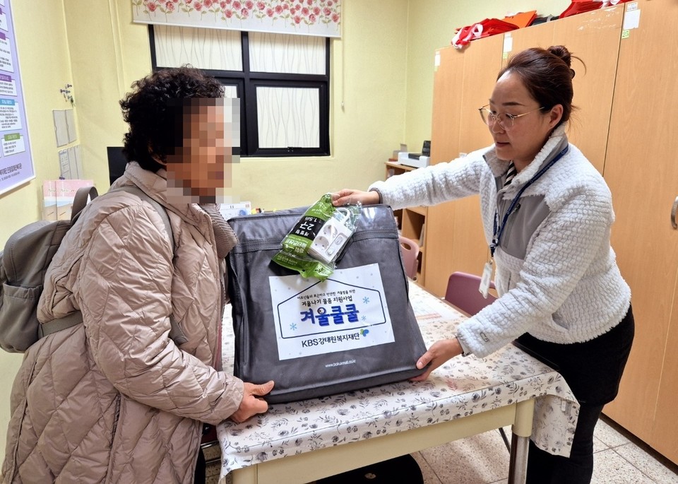 ▲ 단양장애인복지관 관계자(오른쪽)가 장애인 가족에게 온열매트를 전달하고 있다. 사진=단양군제공