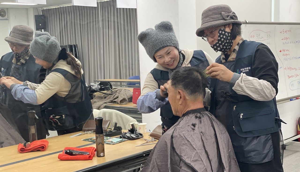▲ 단양군 적성면 귀농귀촌협의회가 마을 어르신에게 미용봉사를 해주고 있다. 사진=단양군제공