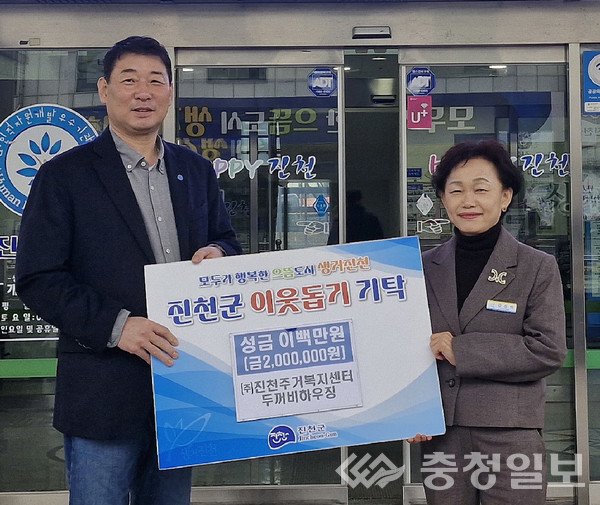 ▲ ㈜진천주거복지센터 두꺼비하우징 김덕수 대표(왼쪽)가 27일 충북 진천군 종합사회복지관에서 강선미 군 주민복지과장에게 취약계층 이사비를 기탁한 뒤 기념촬영하고 있다.