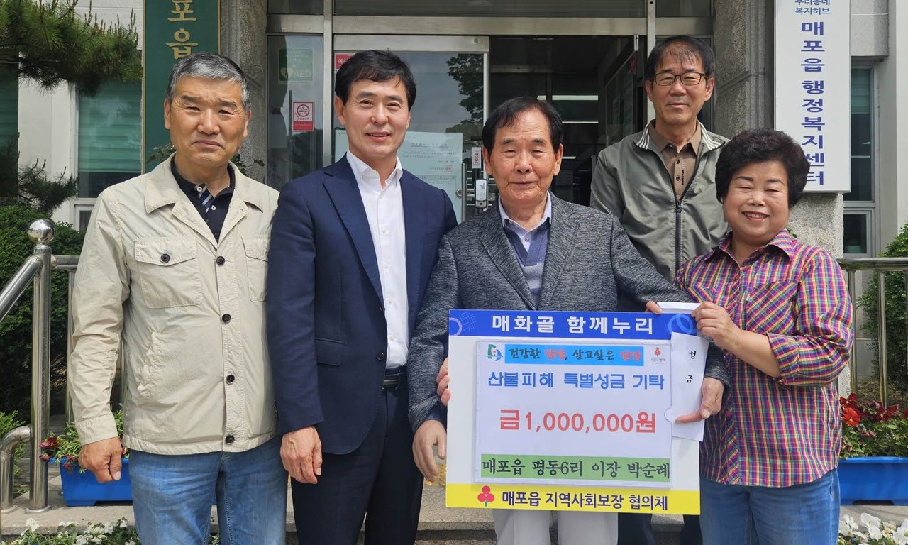 ▲ 박순례 매포읍 평동6리 이장(앞줄 오른쪽)과 마을회가 매포읍에 성금을 전달하고 사진촬영을 하고 있다. 사진=단양군제공