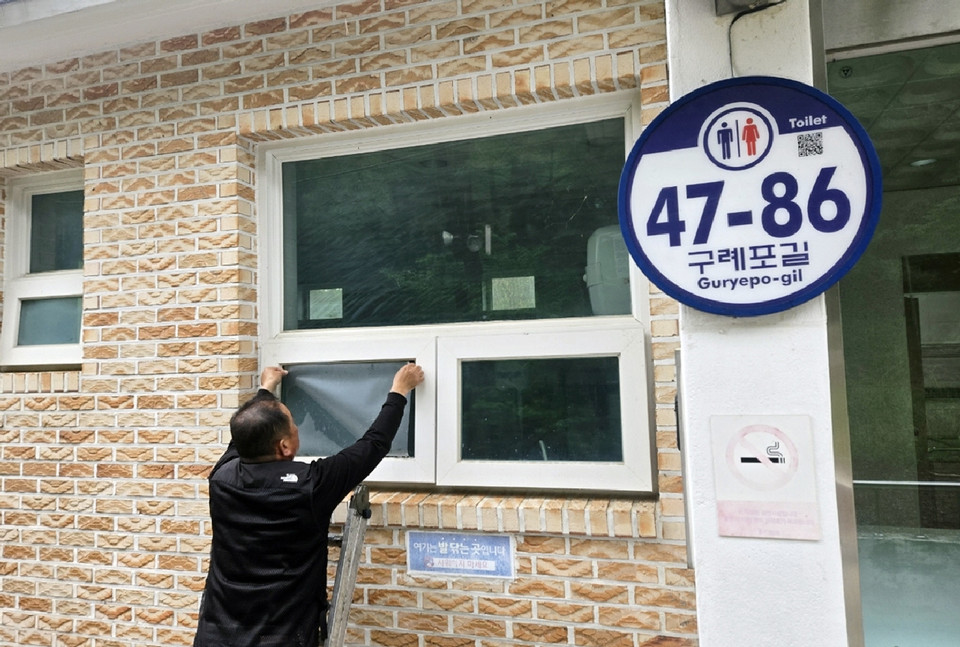 ▲ 이달 초 공중화장실 유리창에 불투명 시트지를 부착하는 모습