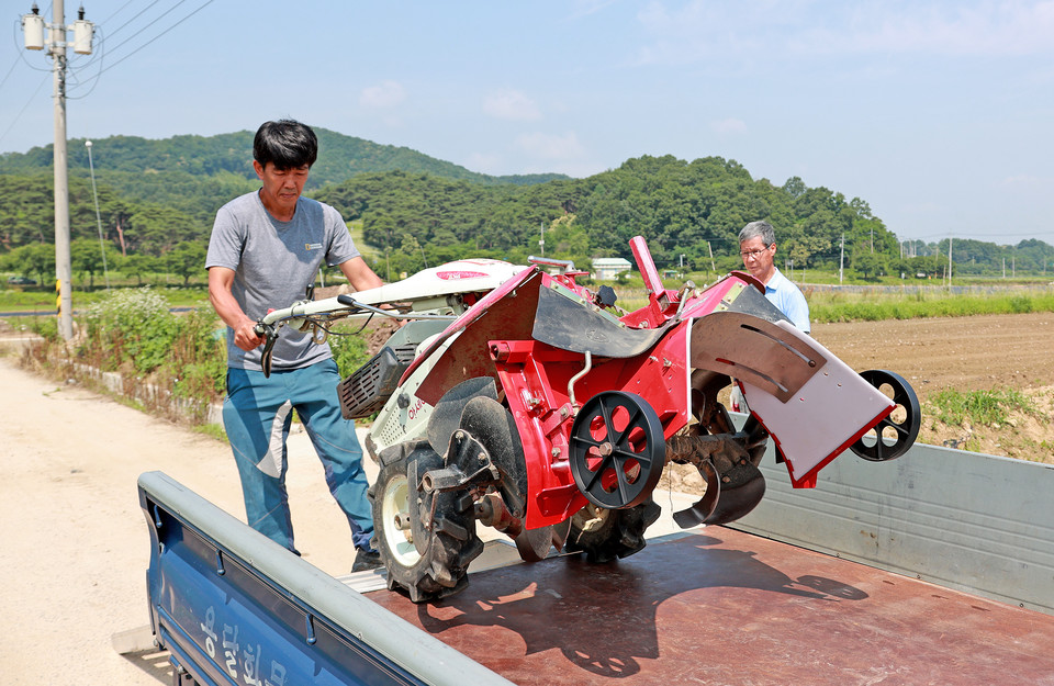 ▲ 괴산군 농가에 농기계 배달 후 트럭에서 농기계를 내리고 있다.
