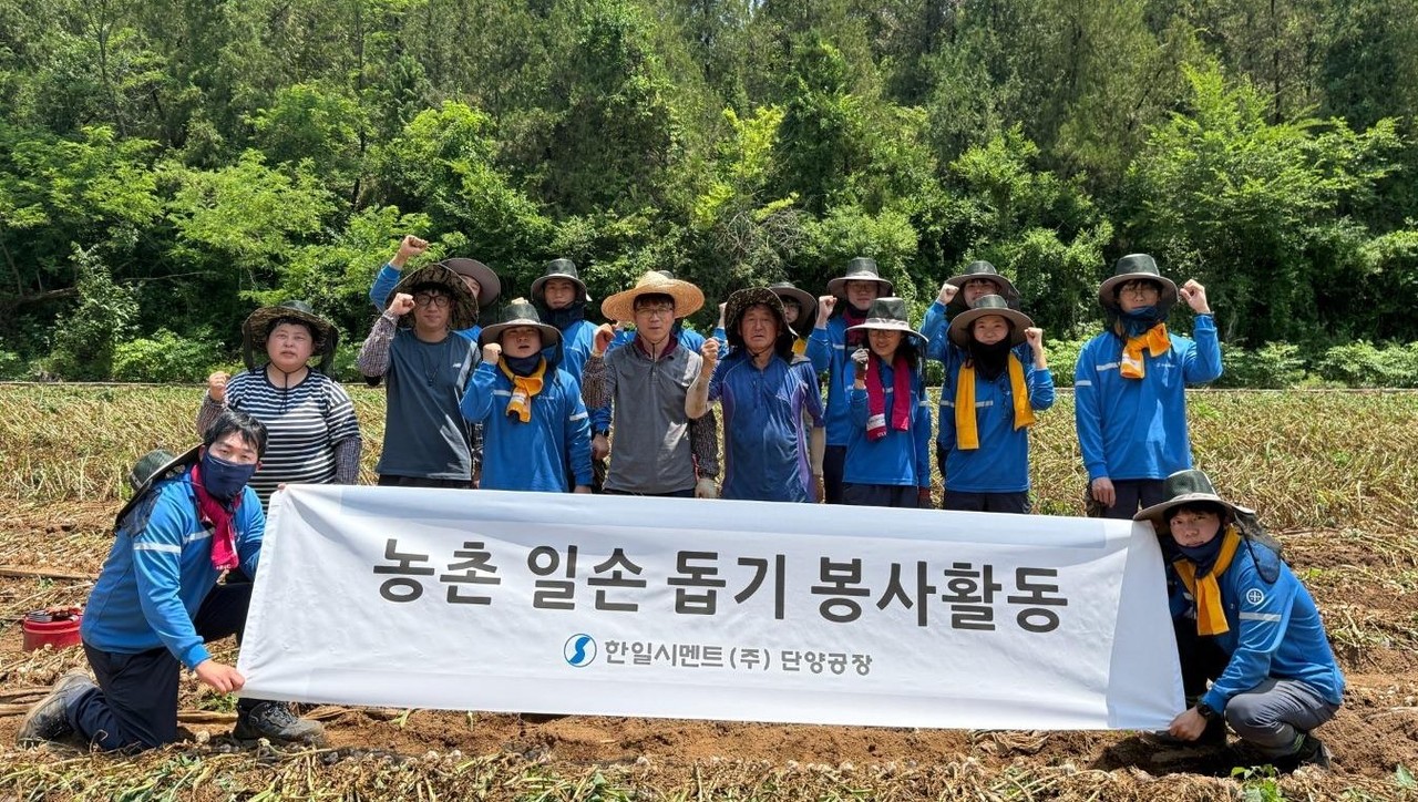 ▲ 한일시멘트 직원들이 마늘 수확을 마치고 사진촬영을 하고 있다. 사진=한일시멘트제공