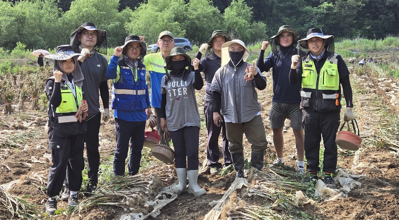 ▲ 지난 19일 성신양회가 단양 도담리 한 농가를 찾아 마늘 수확을 마치고 기념촬영을 하고 있다. 사진=성신양회제공