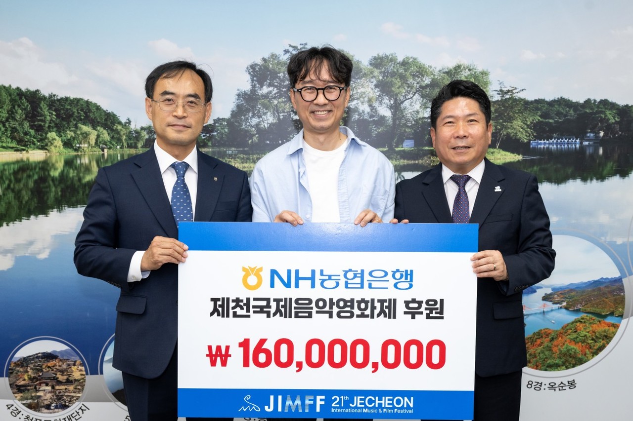 ▲ 이재선 농협 제천시지부장(왼쪽)이 제천국제음악영화제에 후원금을 전달하고 있다. 사진=제천시제공