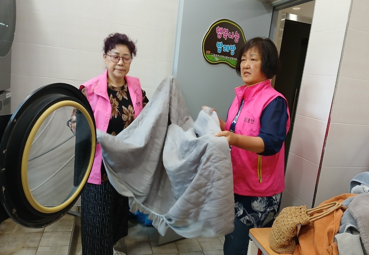 ▲ 단양군 영춘면지역사보협 위원들이 세탁물을 건조기에 넣고 있다. 사진=단양군제공