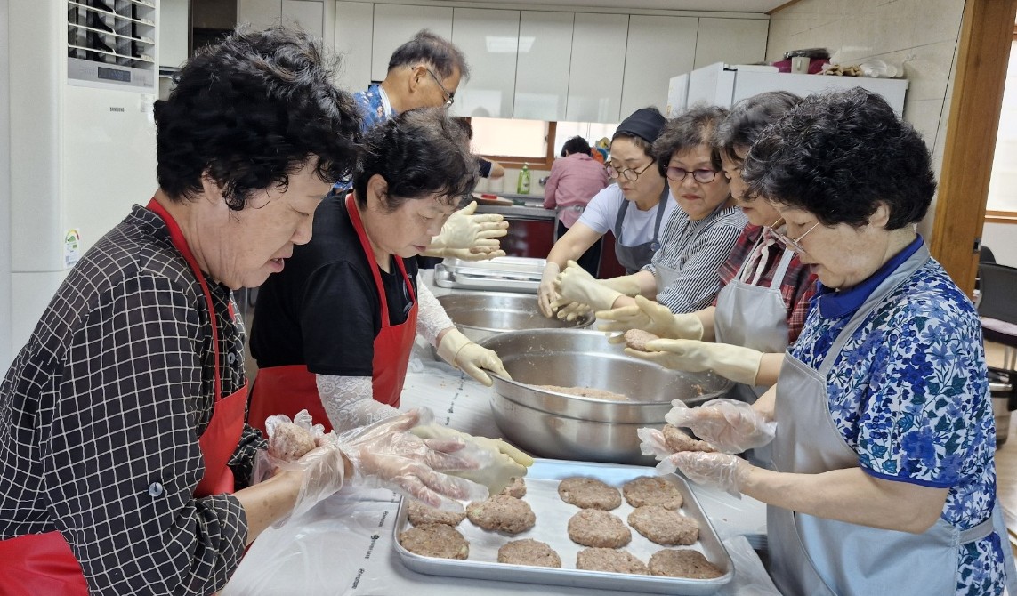 ▲ 경로당 요리교실에 참여한 경로당 회원들이 요리 전문가의 도움으로 떡갈비를 만들고 있다. 사진=제천시제공