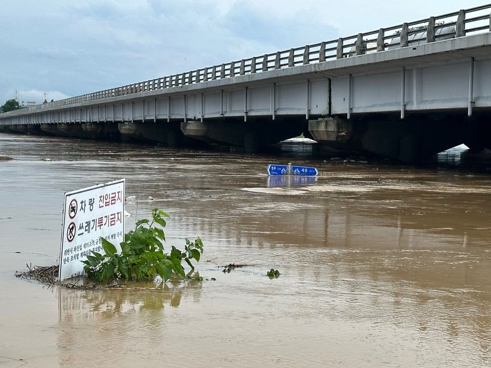 17일 오후 미호강이 불어나 강변의 자전거 도로 표지판이 물에 잠기고 있다. /조은영기자