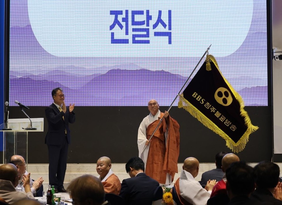 ▲ 현진 스님이 BBS 청주불교방송 사장 취임식에서 서진영 BBS불교방송 사장으로부터 청주불교방송기를 전달받고 있다.