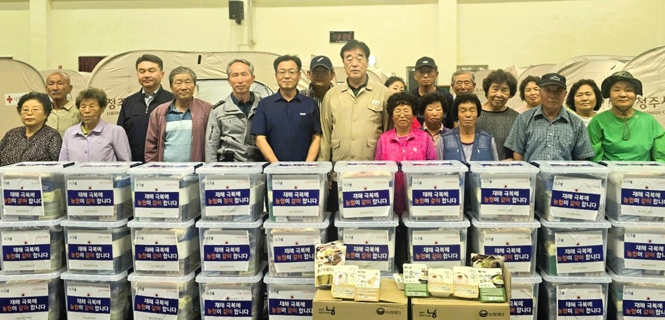▲ 변익수 조합장(앞줄 가운데)이 청주시 북이면 화상2리 고상찬 이장과 긴급 대피한 주민들에게 구호 물품을 전달했다.