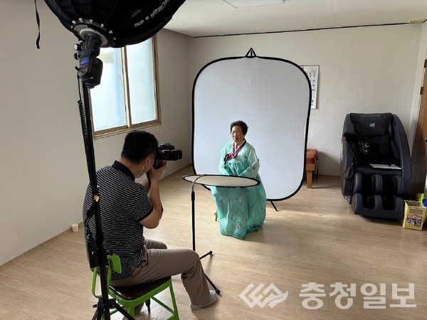 ▲ 충북 진천군 초평면 주민자치회 관계자가 23일 초평면의 한 경로당에서 어르신 장수사진을 촬영하고 있다.