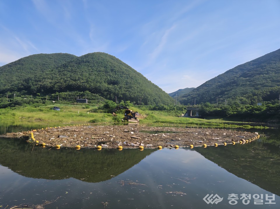 ▲ ​23일 경북 영천 보현산댐 상류 일대 부유물 포집 모습. 포집된 부유물은 굴삭기를 동원해 운반 후 선별작업 등을 거쳐 처리될 예정이다. 현재 댐은 집중호우와 함께 유입된 나뭇가지, 수초류, 생활폐기물 등이 하류에 유입되지 않도록 부유물을 제어하는 1차 방어선으로 작동하고 있다​