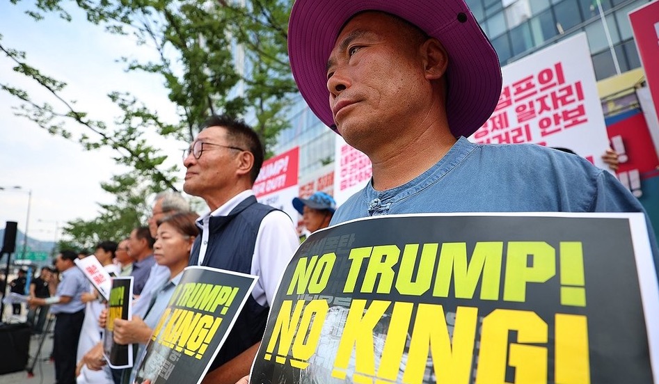 ▲ 한미 관세협상이 타결된 31일 서울 광화문 미국대사관 인근에서 트럼프위협저지공동행동 및 농민의길 주최로 열린 입장발표 기자회견에서 한 참가자가 피켓을 들고 있다./사진:연합뉴스