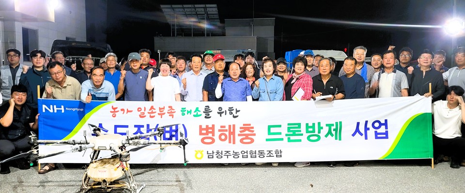 ▲ 이길웅 조합장(앞줄 가운데 왼쪽)과 남청주농협 임직원들이 영농회장, 항공방제 전문가들과 기념촬영을 하고 있다.
