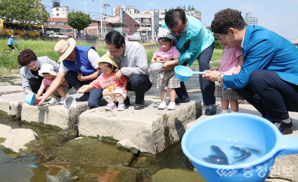 ▲ 사진 중앙 박희조 동구청장이 어린이와 함께 대전천에 치어를 방류하고 있다