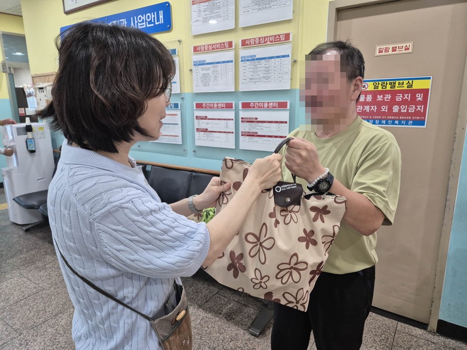 ▲ 단양장애인복지관 직원(왼쪽)이 장애인 가정에 반찬을 전달하고 있다. 사진=단양장애인복지관제공